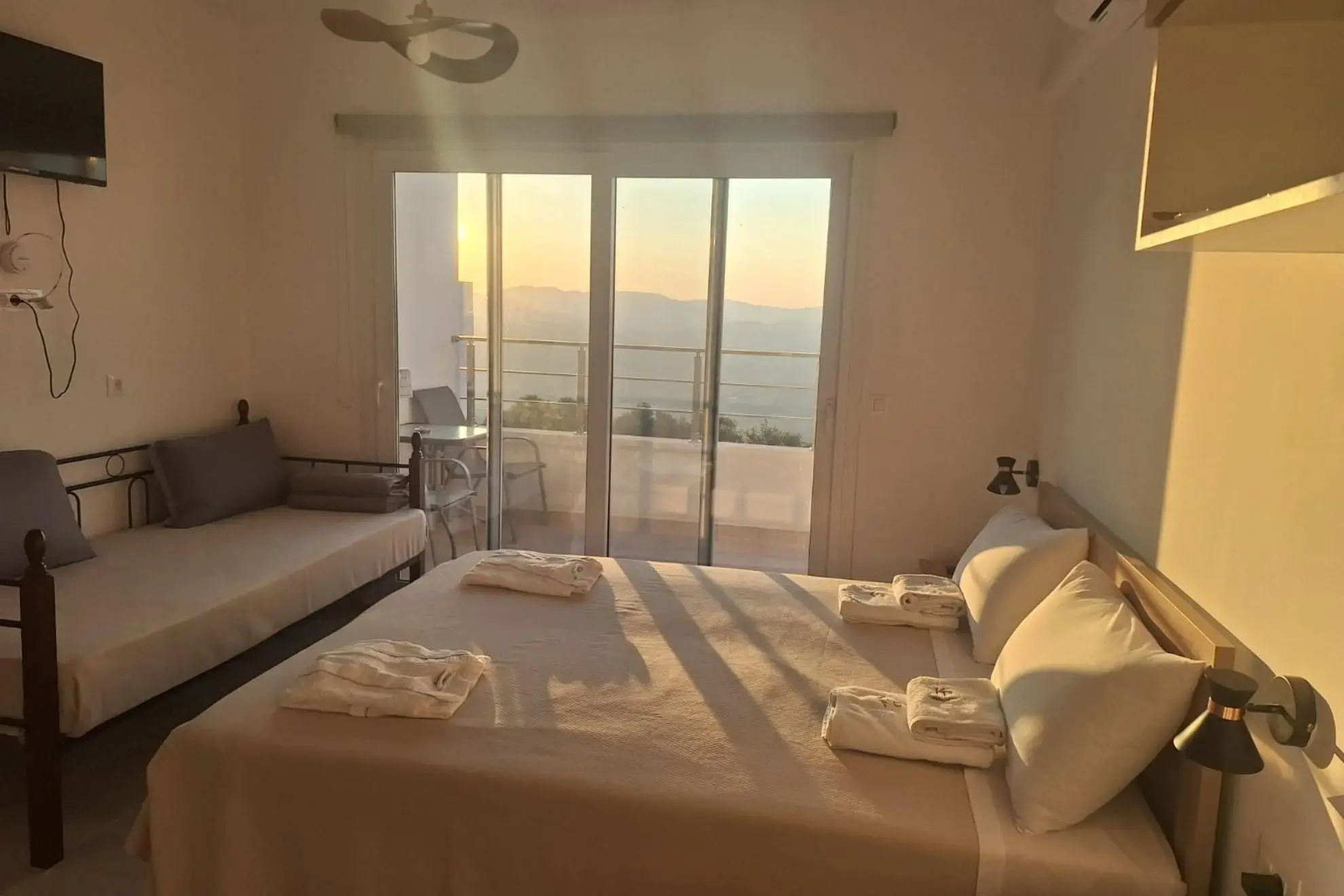 Room with bed, sofa bed, balcony and mountain view